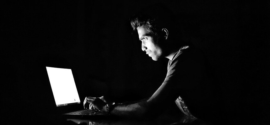 Człowiek w nocy pracuje na komputerze