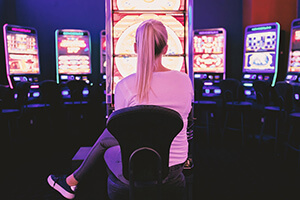 Młoda kobieta gra na automacie hazardowym.